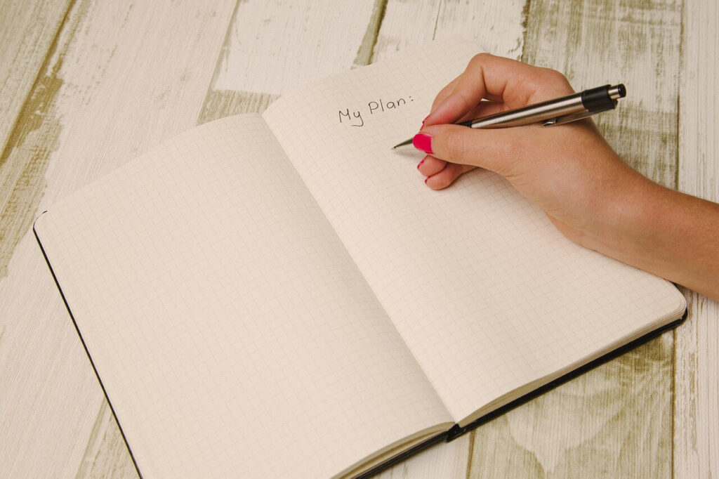 Hand writing in a planner — habit tracking for saving goals