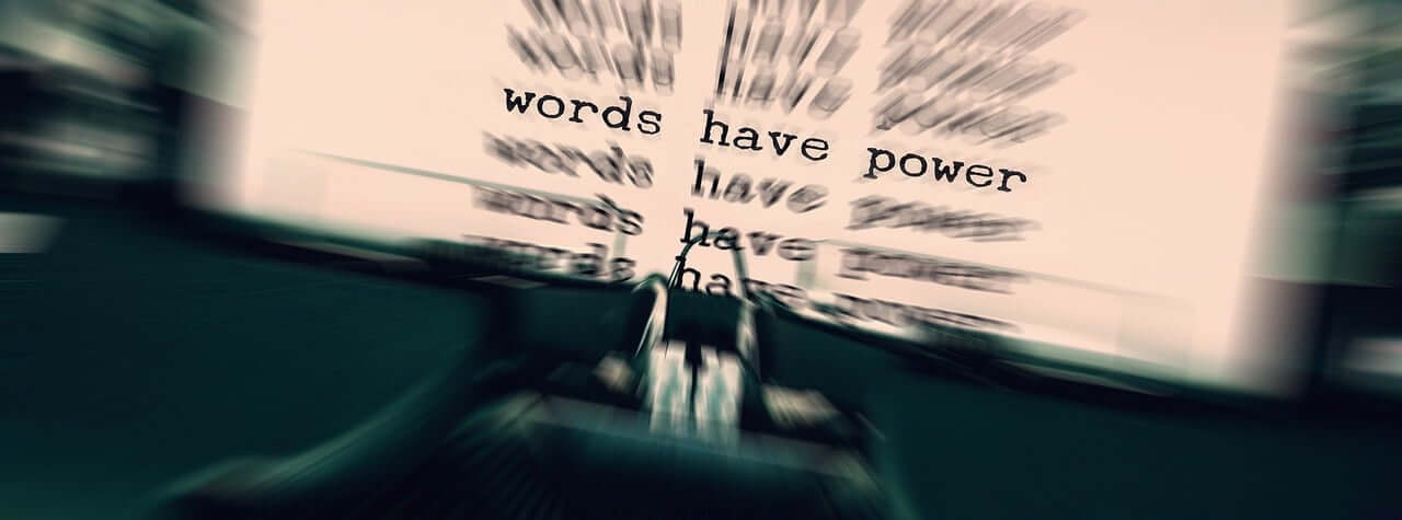 Blurred close-up of typed words on paper with selective focus, representing the power and influence of written language.